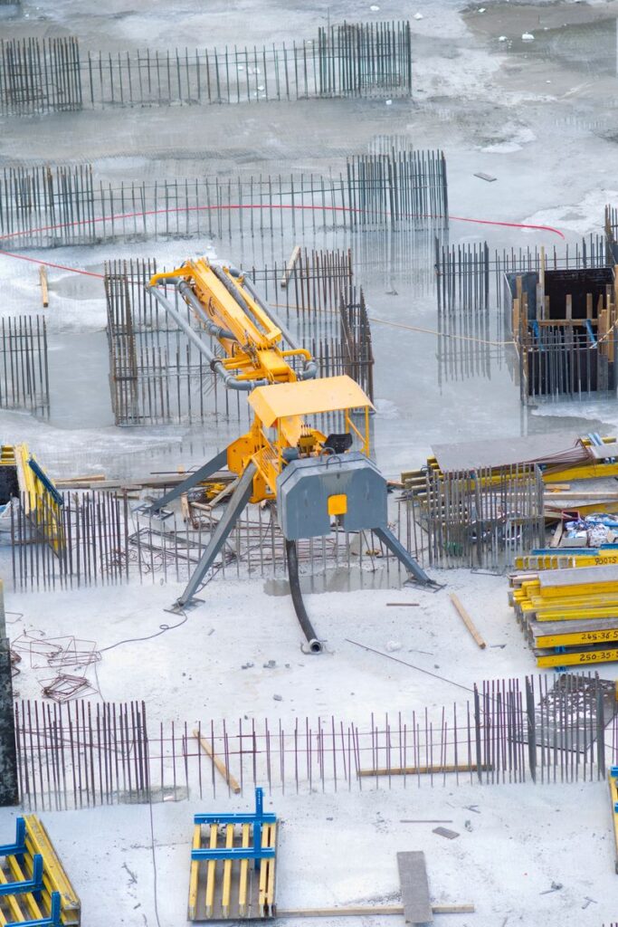 Aerial view of an active construction site with heavy machinery and building materials.